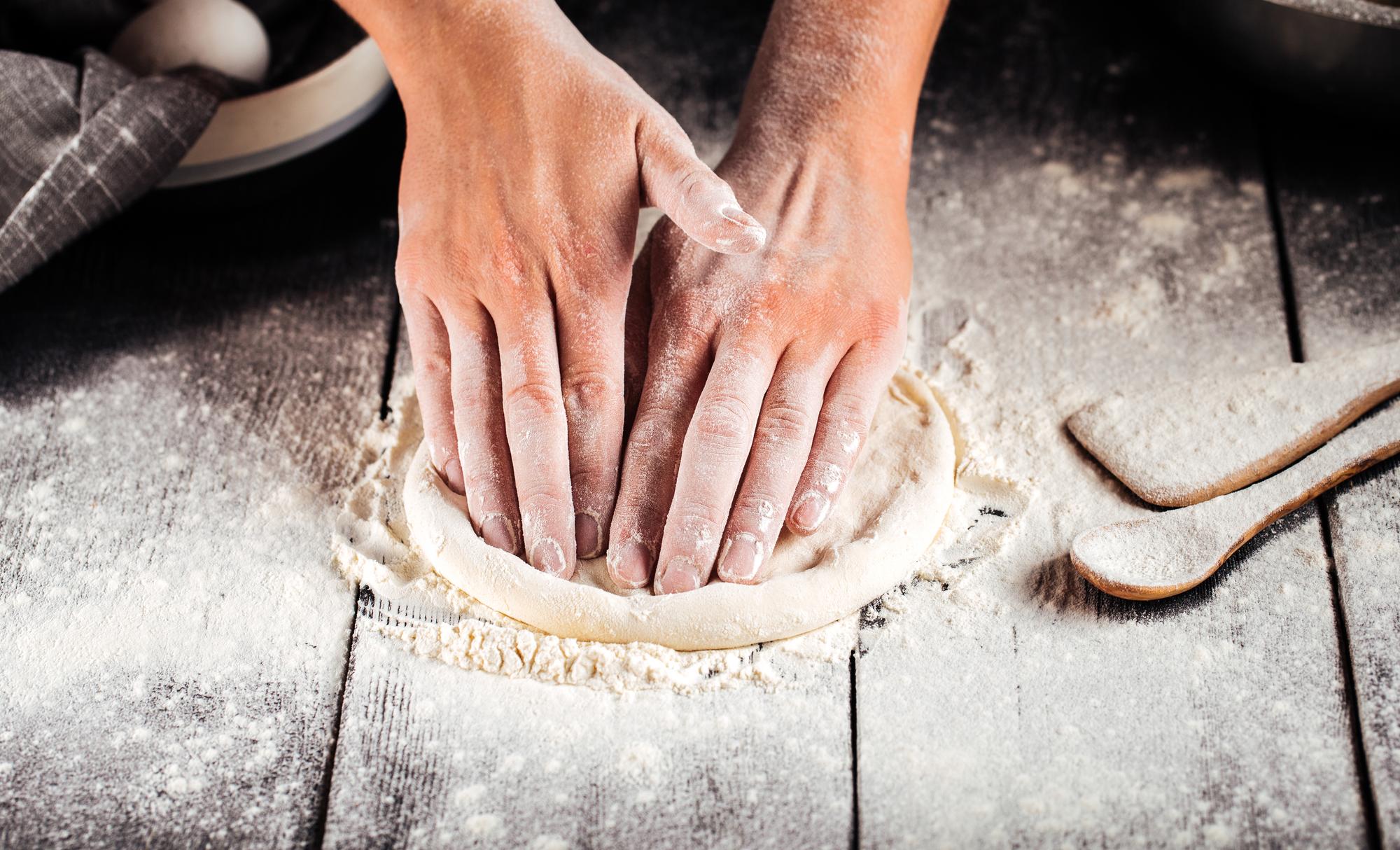 Hands preparing dough in workshop
